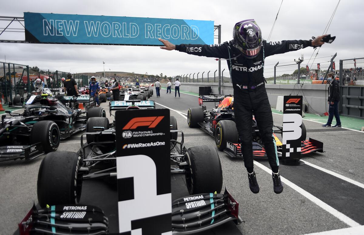Lewis Hamilton jumps out of his car after his record-breaking 92nd win at the Formula One Portuguese Grand Prix.