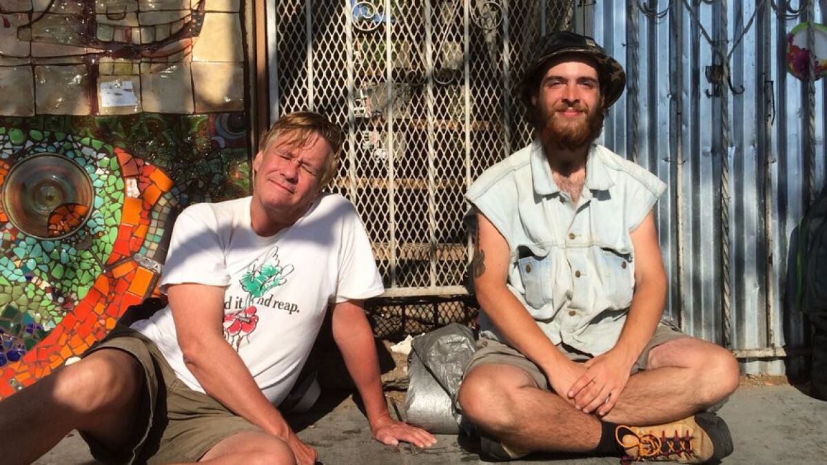 Alex, 61, and Joshua Jones, 22, both homeless in San Diego, sit outside God's Extended Hand soup kitchen on Saturday.
