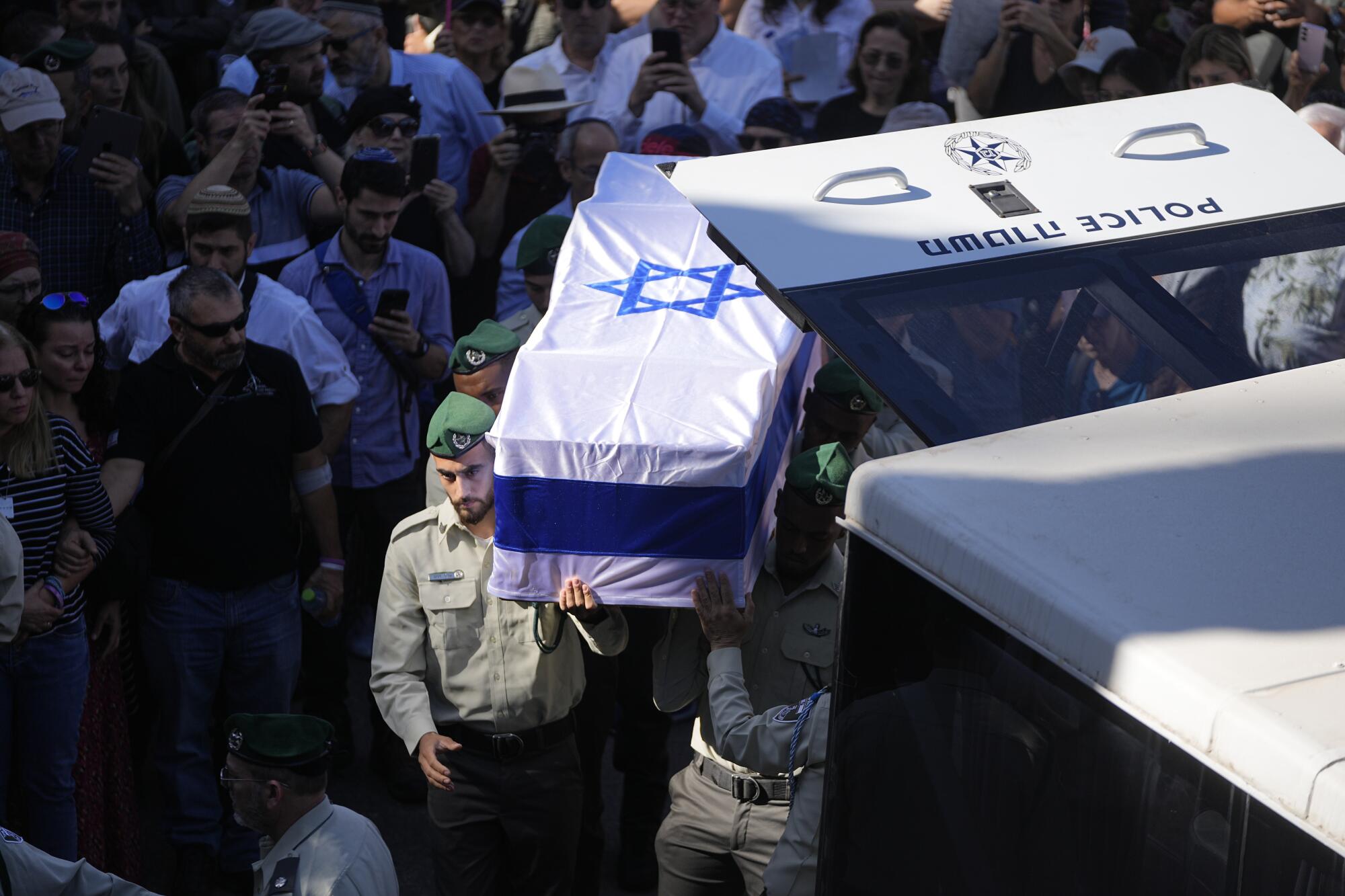Israeli border police officers carry flag-draped coffin of comrade