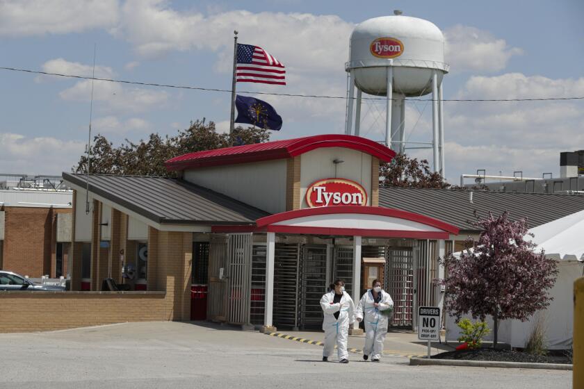 Workers leave the Tyson Foods pork processing plant in Logansport, Ind., Thursday, May 7, 2020. The plant was expected to reopen Thursday after closing on April 25 after nearly 900 employees tested positive for the coronavirus. Workers won't be able to return to work until they get tested. (AP Photo/Michael Conroy)