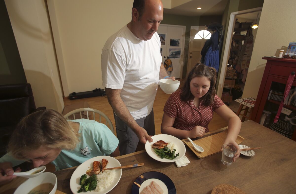 Furloughed chef Aron Schwartz serves lunch to his children Max, left, and Rhyan, right.