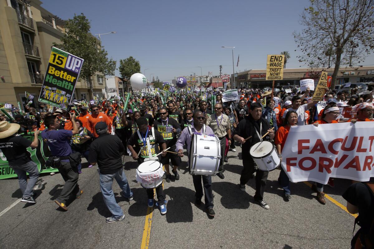 About 1,000 demonstrators -- including union members, fast-food employees and child-care workers -- march for higher wages Wednesday on South Figueroa Street in Los Angeles.