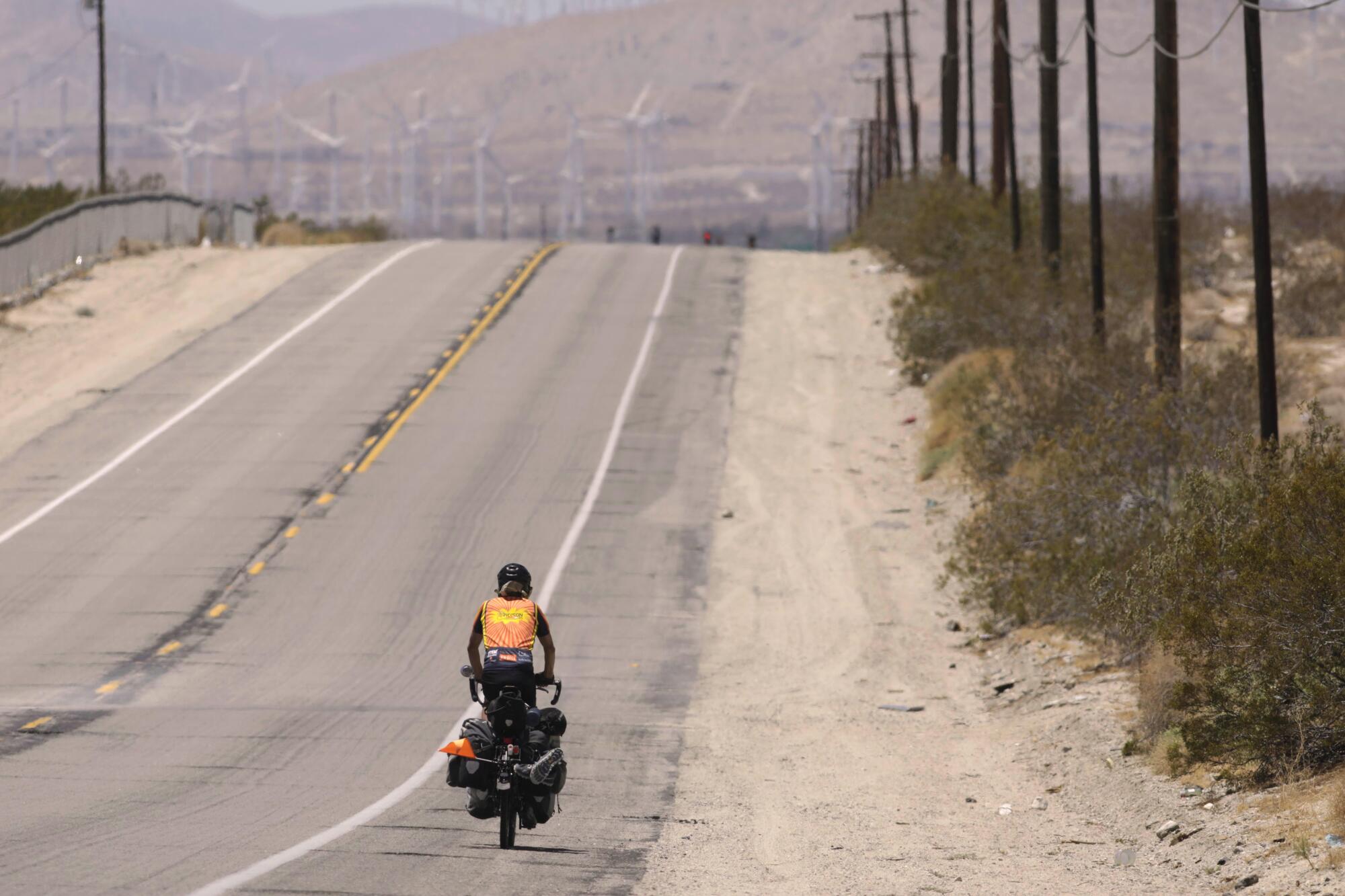 A man that goes by the nickmane Popcorn, 68, rides his bike down Dillon Road in Desert Hot Springs .