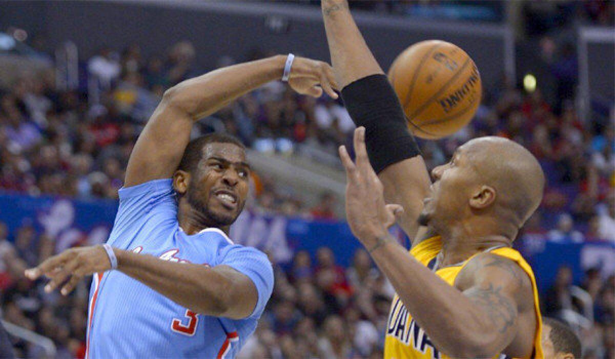 Chris Paul throws a pass behind Indiana's David West during the Clippers' 105-100 loss to the Pacers on Sunday.