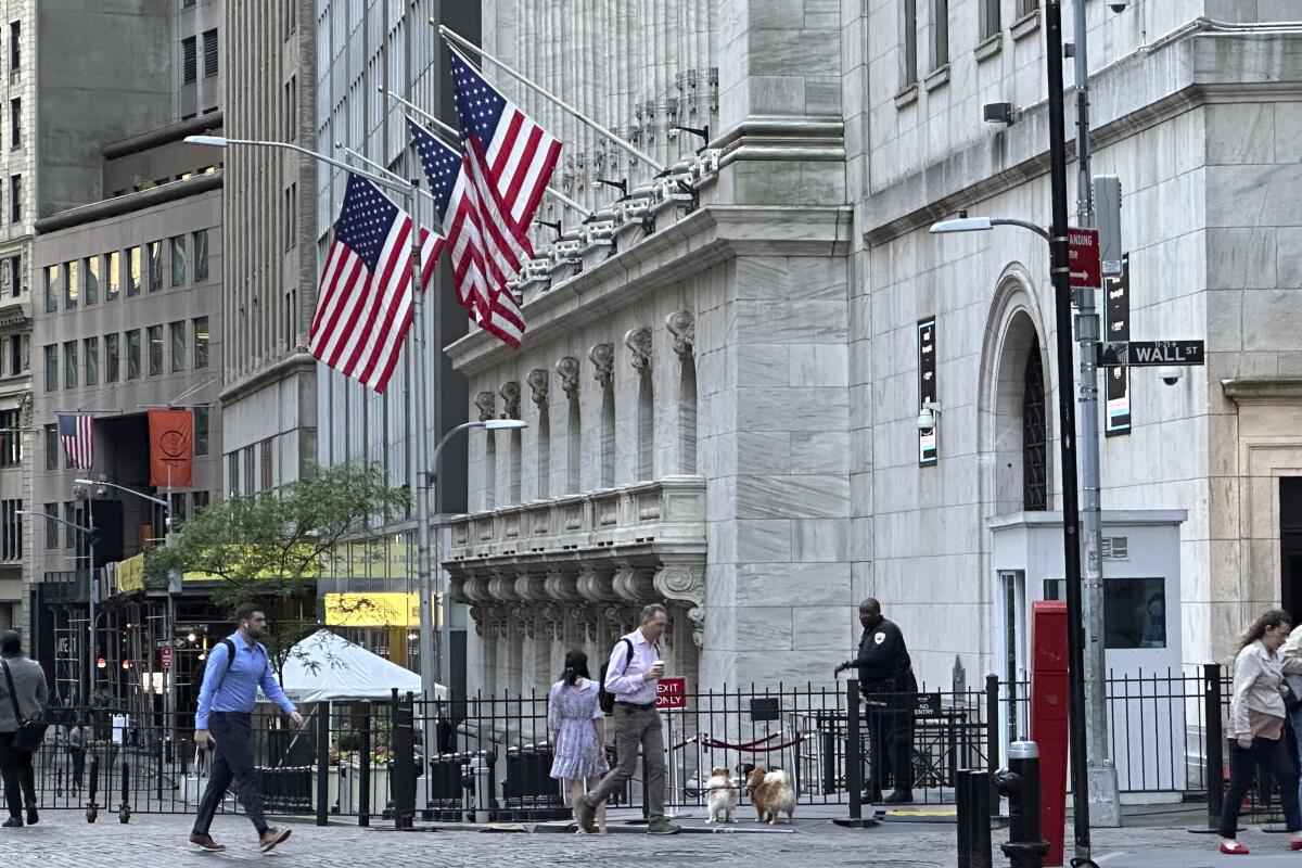 People pass the New York Stock Exchange 