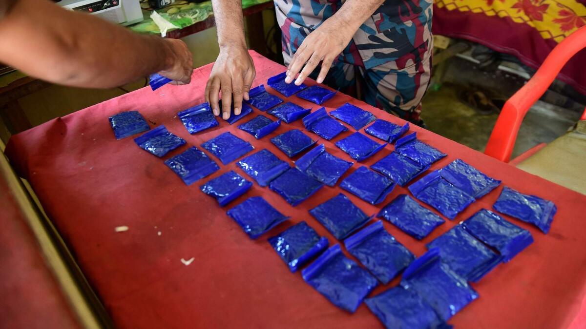 A Bangladesh border police officer displays bags of the drug yaba recovered from a passenger bus near the Myanmar border in April 2018.