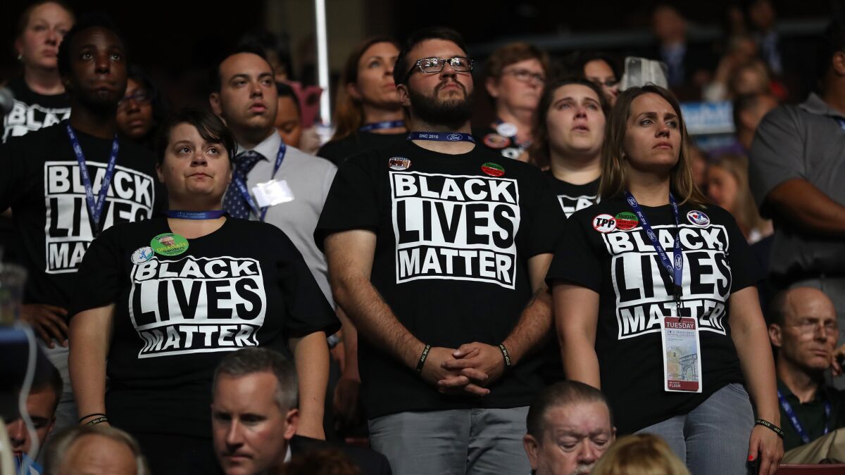 Supporters of the Black Lives Matter movement stand during remarks from the Mothers of the Movement on the second day of the Democratic National Convention.