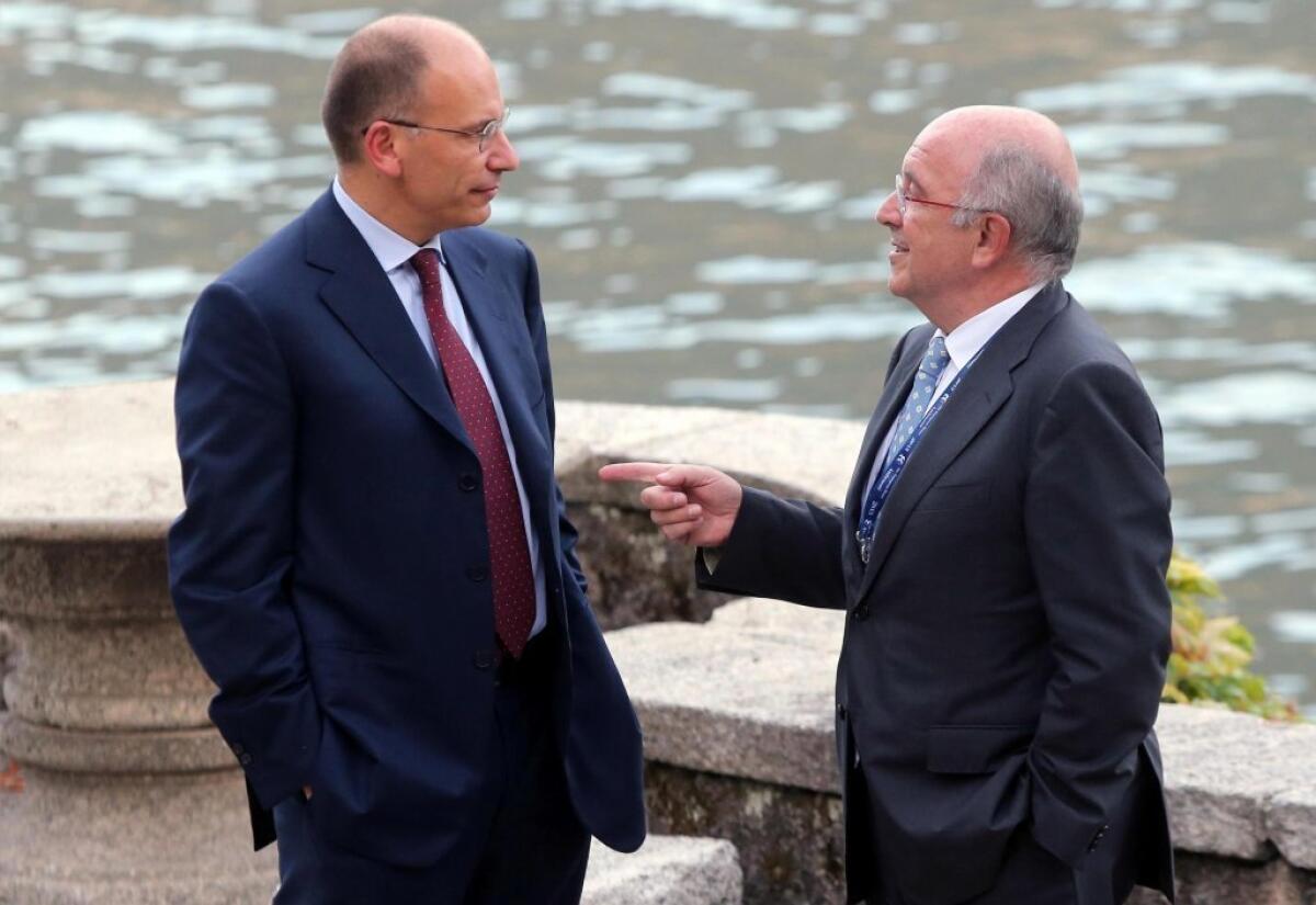 Italian Prime Minister Enrico Letta, left, chats with Joaquim Almunia, European commissioner for competition, at the annual global and economic get-together at the Villa d'Este on Italy's Lake Como.