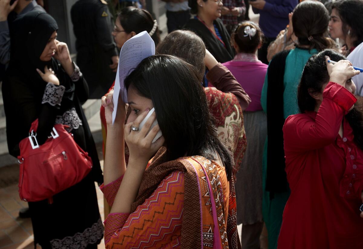 People evacuate buildings and call their relatives after an earthquake was felt in Karachi, Pakistan.