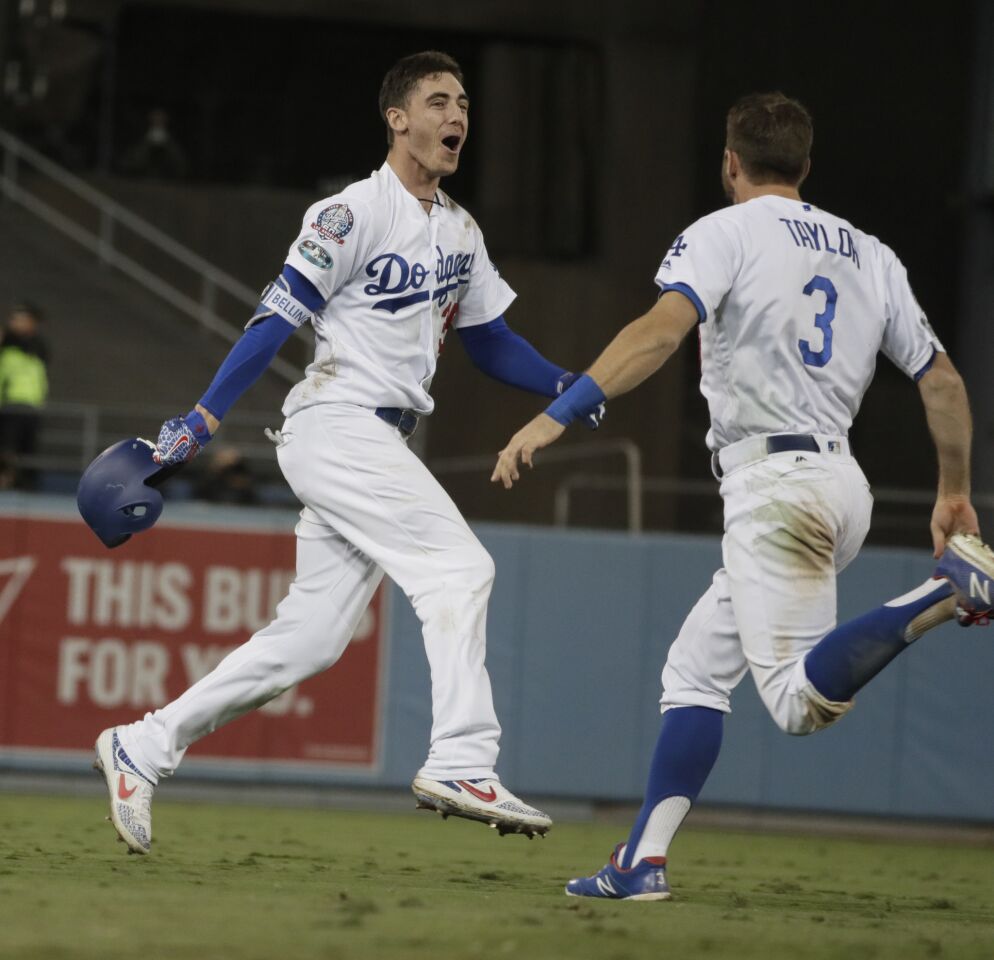 Dodgers Cody Bellinger celebrates with Chris Taylor after driving in the winning run n the 13th inning of game 4 between Dodgers and Brewers.