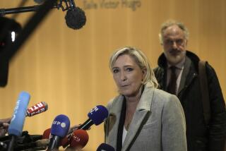 French far-right leader Marine Le Pen, front, speaks to the media as she arrives at the court house in Paris, Monday, Sept. 30, 2024. (AP Photo/Thibault Camus)