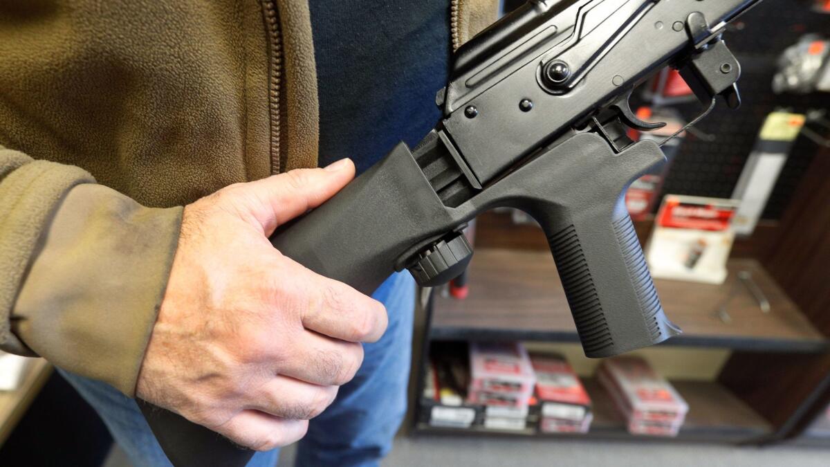 A "bump stock" device is installed on an AK-47 semiautomatic rifle at a gun store in Salt Lake City.