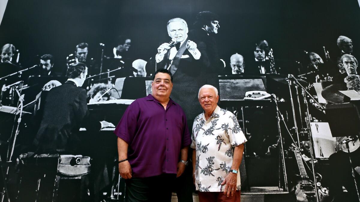 Rick Baptist, left, vice president of the American Federation of Musicians Local 47, and union member and KKJZ radio personality Jerry Sharell stand in front of Sharell's 13-foot-by-16-foot photo mural in the new union office in Burbank on Friday.
