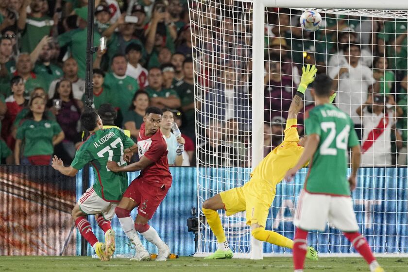 Mexico forward Hirving Lozano, left, scores on Peru goalkeeper Pedro Gallese, second from right, as defender Marcos Lopez, second from left, and forward Carlos Antuna watch during the second half of a soccer match Saturday, Sept. 24, 2022, in Pasadena, Calif. (AP Photo/Mark J. Terrill)