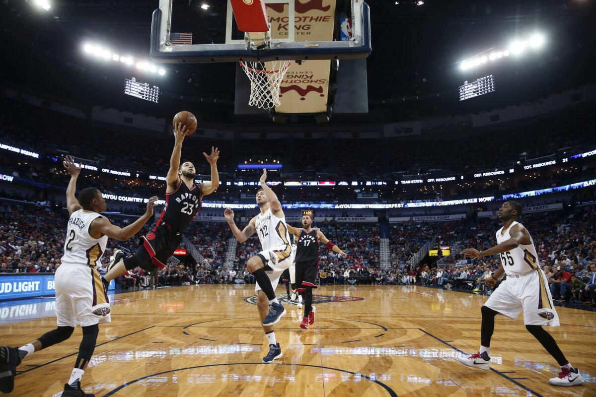 El jugador de los Raptors de Toronto entra a canasta ante la defensa de los Pelicans de Nueva Orleans.