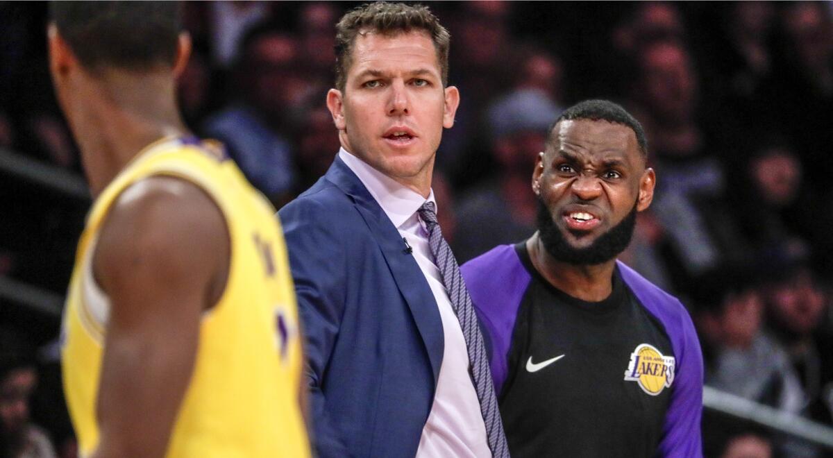 Lakers coach Luke Walton and forward LeBron James talk to guard Rajon Rondo during a break in the action against the Rockets on Feb. 21.