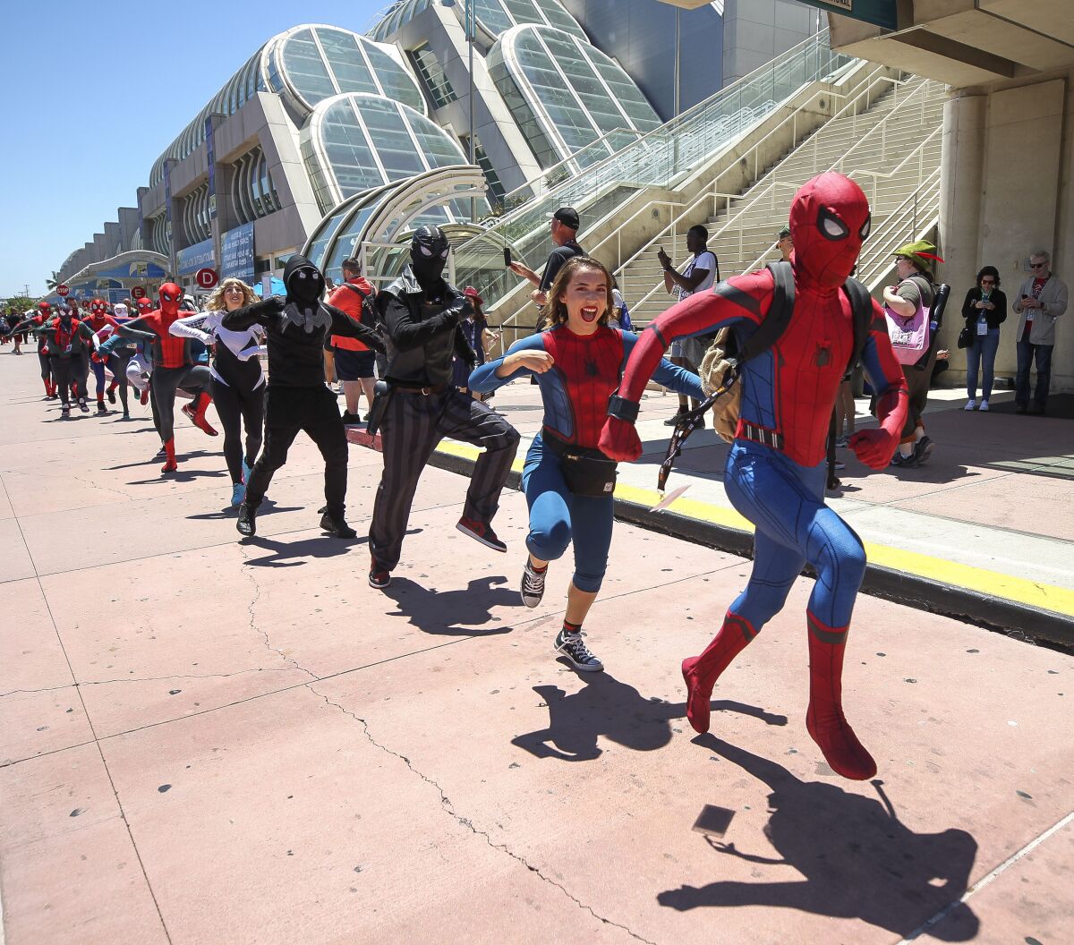 Comic-Con convention-goers dressed in various iterations of Spider-Man dance in front of the San Diego Convention Center for a YouTube video on Saturday.