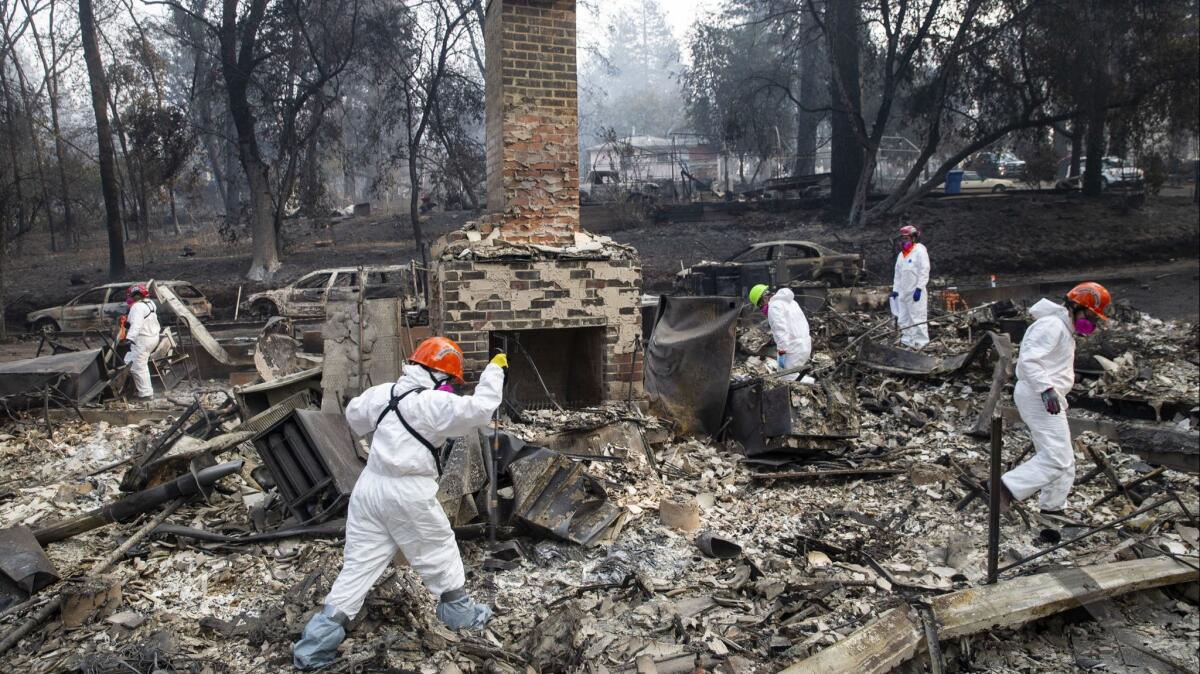 Search teams inspect the grounds of a house burned by the Camp fire in Paradise, Calif., in November.