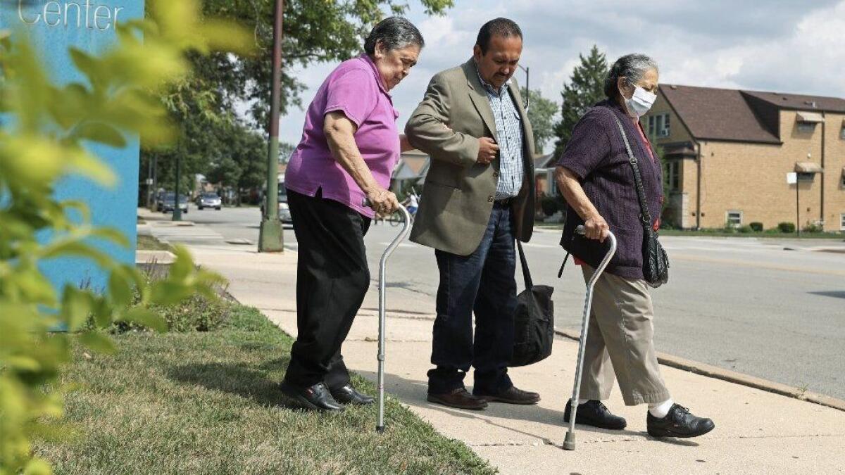 Alvaro Obregon assists his mother, Felicitas Obregon, 86, left, and aunt, Elena Gaytan, 77, to medical appointments on Aug. 9, 2018, on Chicago's Southwest Side. Obregon, who works for AARP Illinois, takes his mom to appointments twice a month, and his aunt about twice a week.