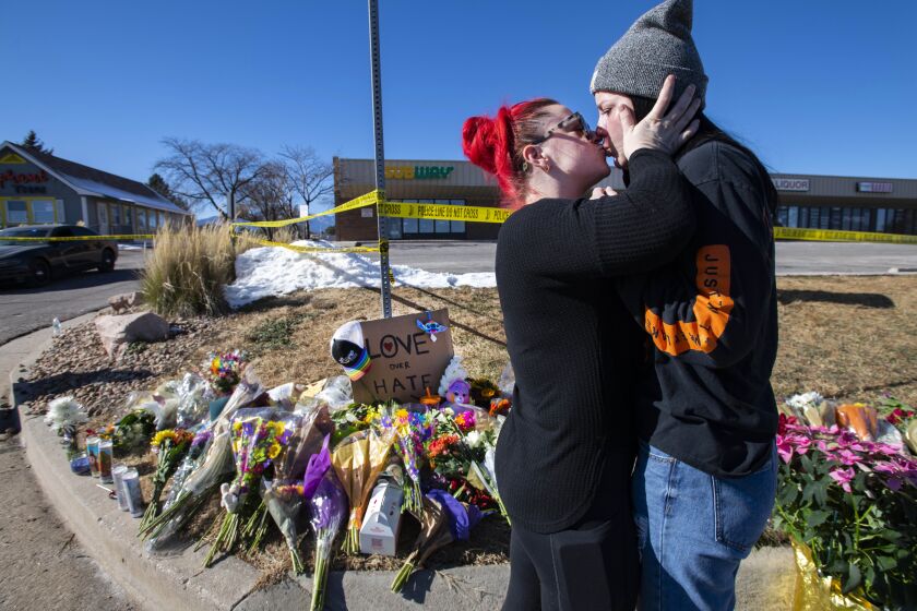 Sophie Kamerrer, left, and Torrey Lovett embrace while visiting a makeshift memorial near Club Q Sunday, Nov. 20, 2022, after a shooting Saturday night at the Colorado Springs, Colo., bar. (Christian Murdock/The Gazette via AP)