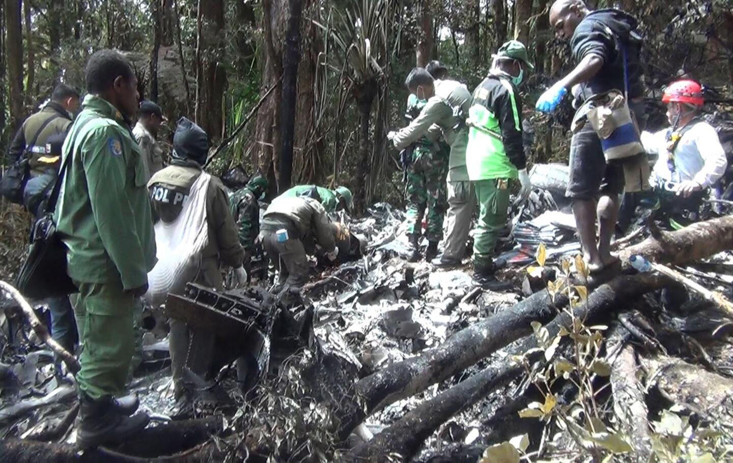 Indonesian rescuers search through wreckage of the Trigana Air ATR 42-300 twin-turboprop plane at the crash site in the mountainous area of Oksibil on Aug. 18, 2015. Fifty-four people died in the crash.