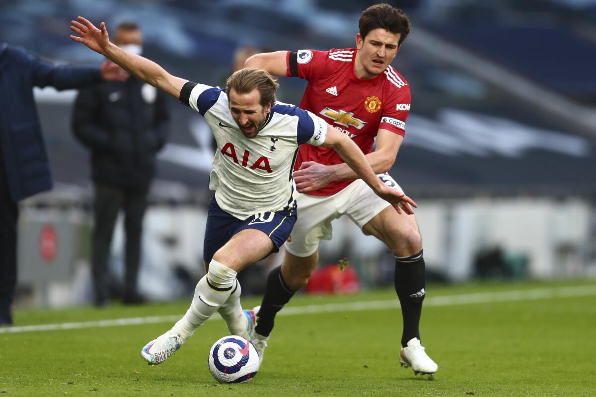 Harry Kane (izquierda) de Tottenham pugna el balón con Harry Maguire del Manchester United 
