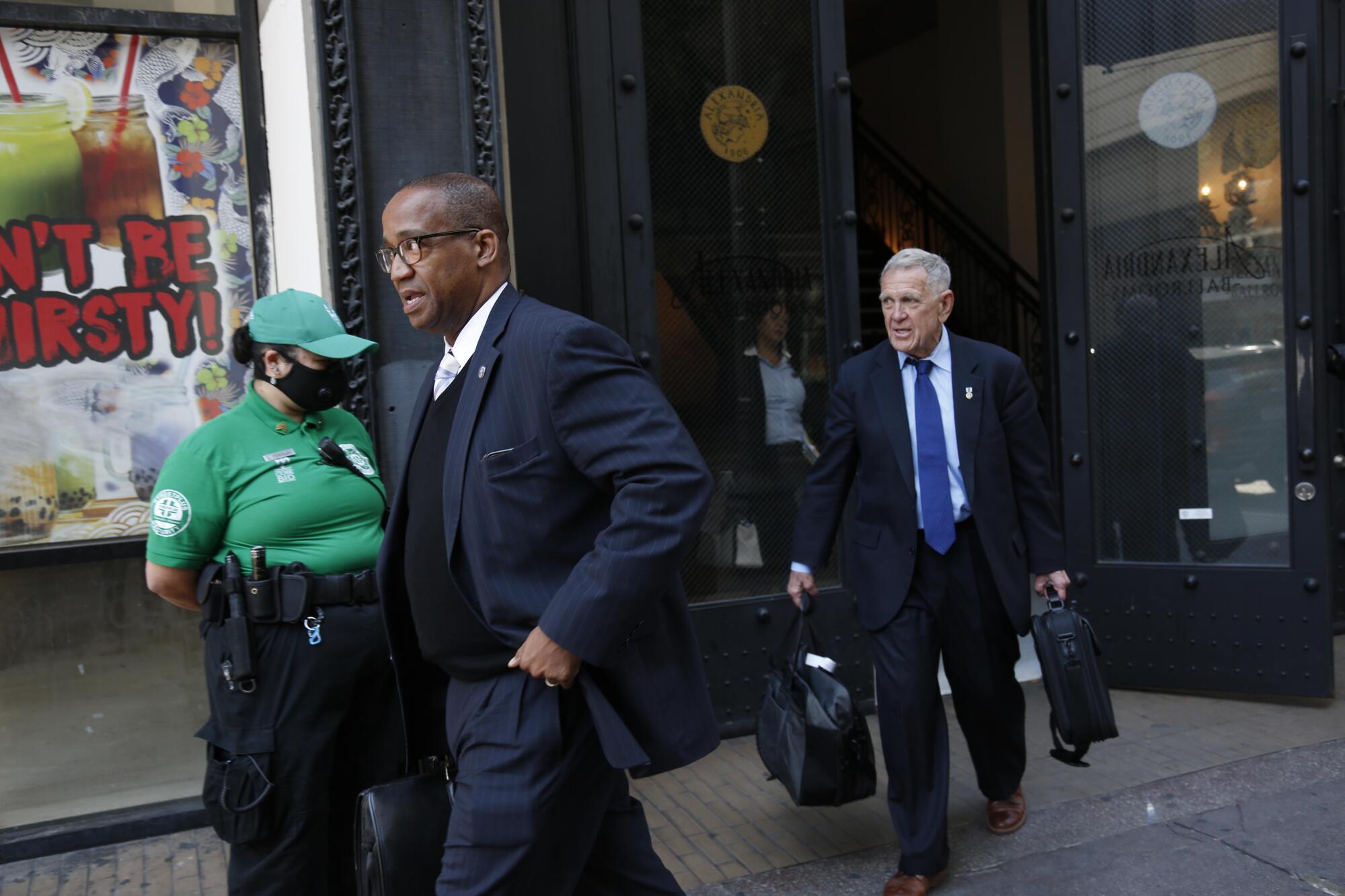 U.S. District Judge David Carter, right, and U.S. District Judge Andre Birotte, Jr., leave a closed Federal court hearing to discuss possible immediate solutions to the Skid Row homeless crisis in light of the worsening coronavirus pandemic at the Alexandria Hotel in downtown Los Angeles.