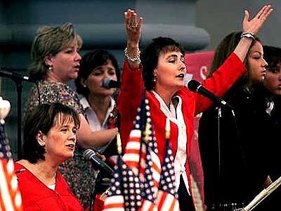 Renee Bondi, left, and Terese Henriks lead singers at a memorial Mass at the San Juan Capistrano Mission Basilica Church.