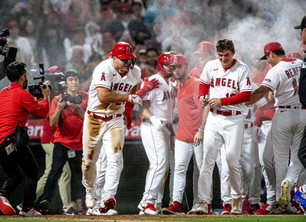 Angels teammates swarm center fielder Mike Trout and spray him with powder.
