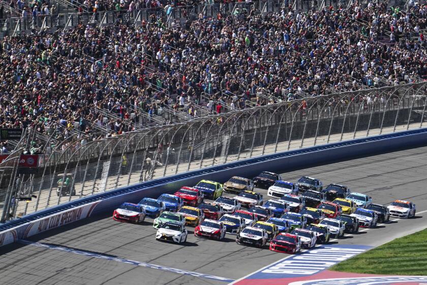 NASCAR Cup Series cars line up five wide in a salute to fans during pace laps for the NASCAR Cup Series auto race at Auto Club Speedway, in Fontana, Calif., Sunday, March 17, 2019. (AP Photo/Rachel Luna)