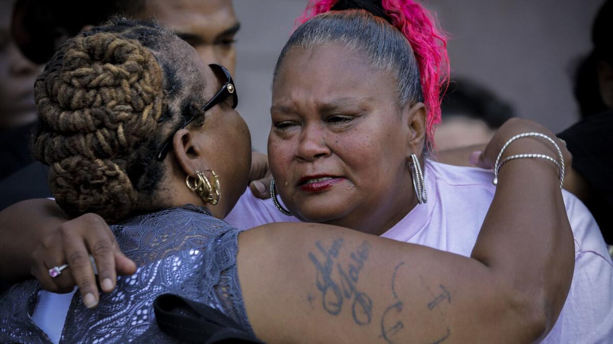 Family friend Theresa Arnold, left, comforts Samantha Mays at a news conference held to announce a $50,000 award for information leading to an arrest in the fatal April shooting of her 15-year-old daughter, Hannah Bell.