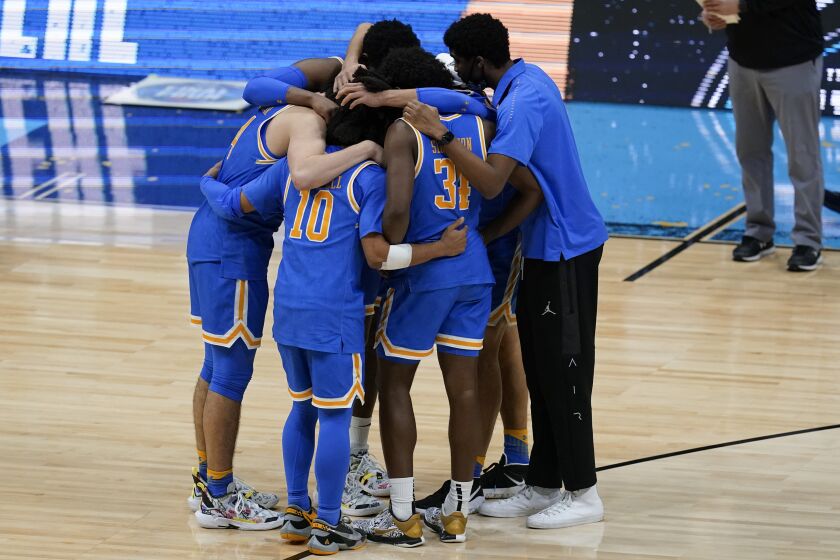 UCLA players huddle on the court after falling 93-90 in overtime to Gonzaga Saturday at Lucas Oil Stadium in Indianapolis.