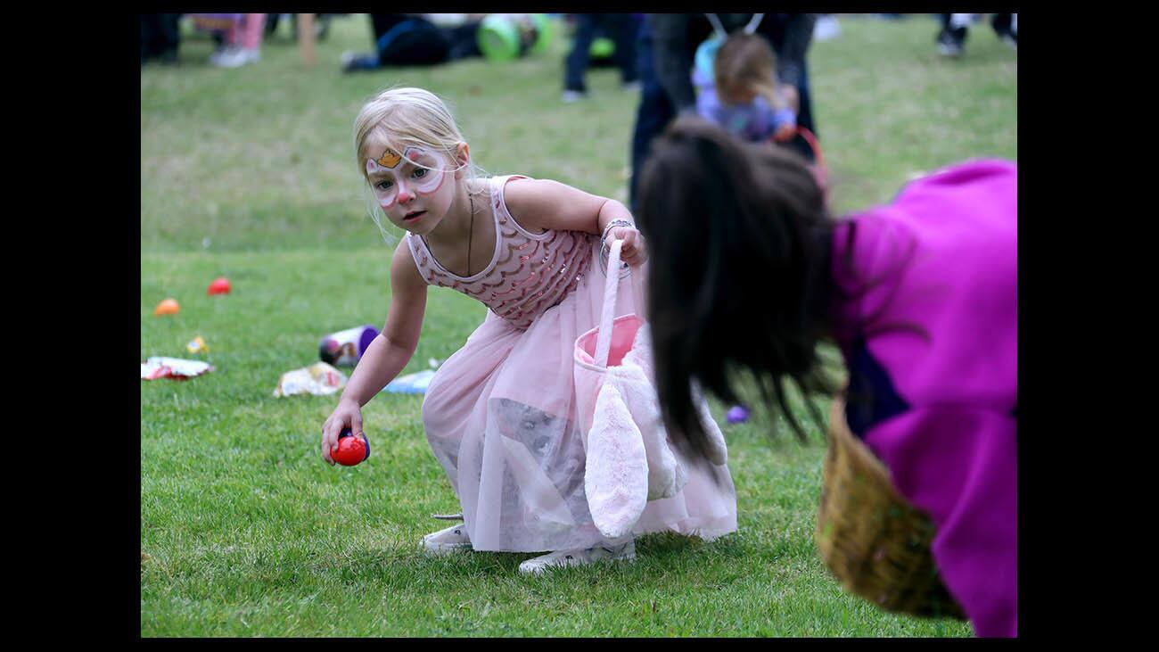 Brooke Coupe, 3 of Huntington Beach, gathers up candy and Easter eggs at the Easter Egg hunt during the 30th annual Egg-Citement event, sponsored by Torelli Realty, at Tanager Park in Costa Mesa on Saturday, March 31 2018. The event included pony rides, train rides, egg hunts, petting zoo, bounce house and the Adams Elementary School band.