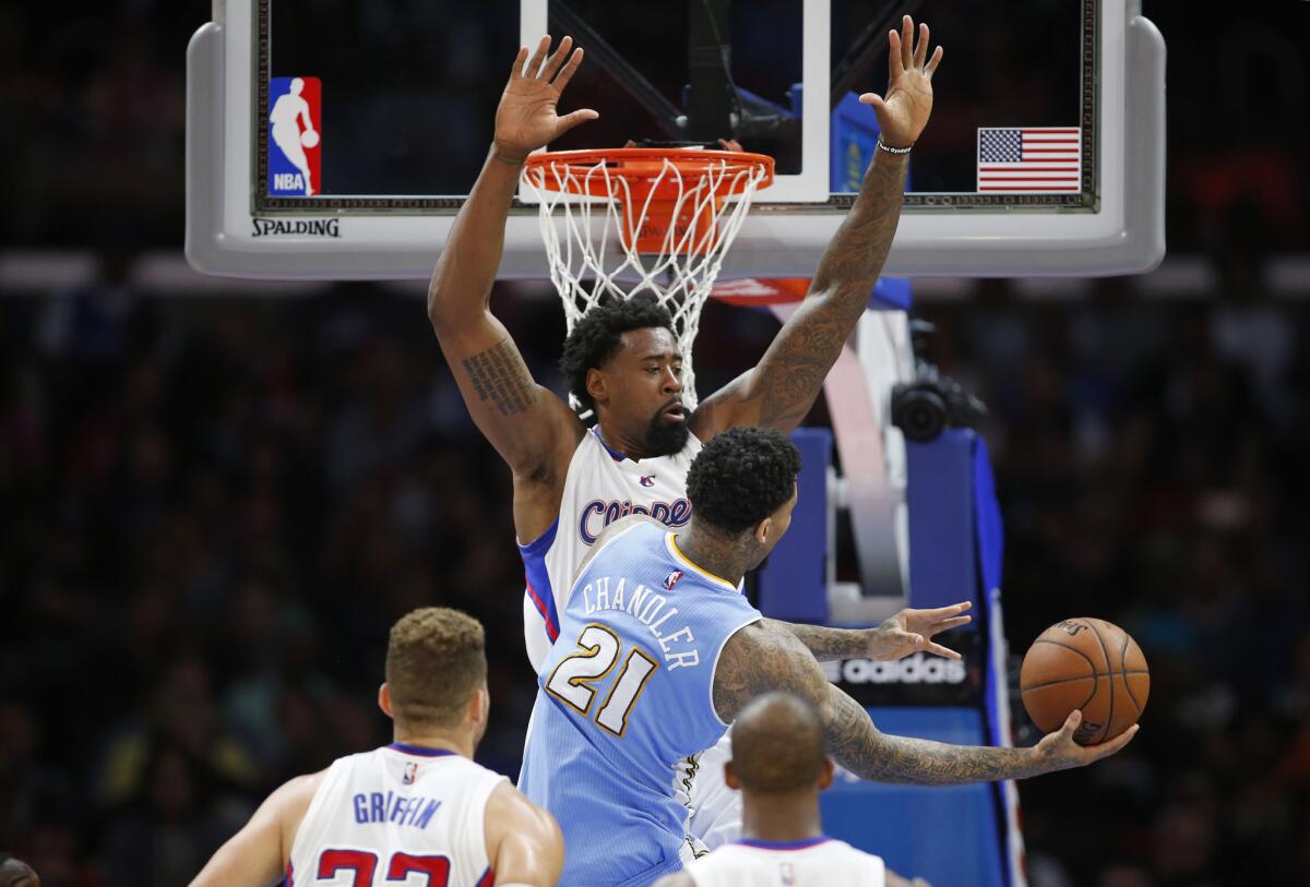 Clippers center DeAndre Jordan defends the basket against Denver Nuggets forward Wilson Chandler during an April 13 game at Staples Center.