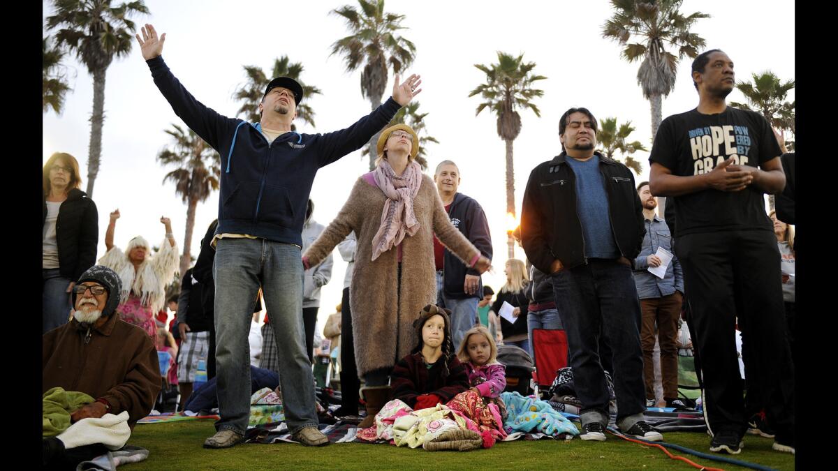 Worshipers gather for a non-denominational, community Easter sunrise service at Huntington Beach Pier Plaza on April 5.