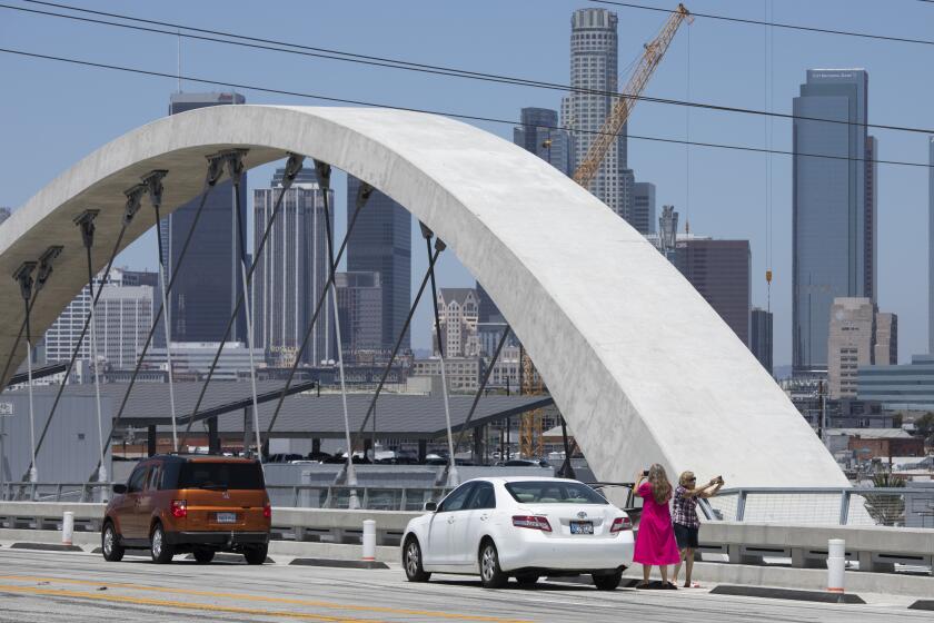 LOS ANGELES, CA - July 19: Cars stop on the 6th Street Viaduct on Tuesday, July 19, 2022 as occupants get out to take pictures. (Myung J. Chun / Los Angeles Times)
