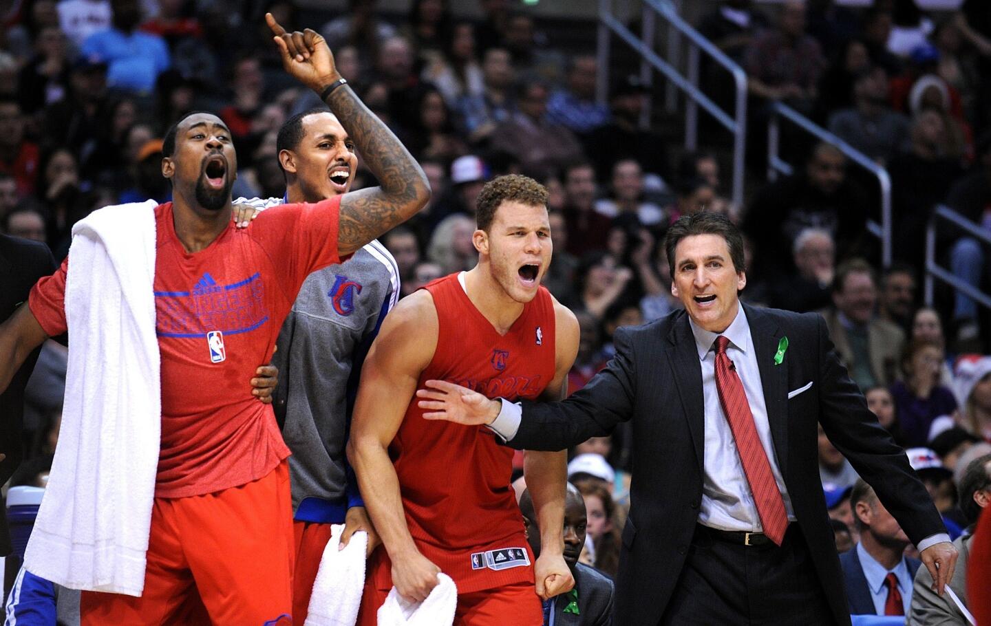 Clippers Coach Vinny Del Negro tries to keep (from left) DeAndre Jordan, Ryan Hollins and Blake Griffin from spilling onto the court as they celebrate in the closing minutes of their 112-100 victory over the Nuggets on Tuesday night.