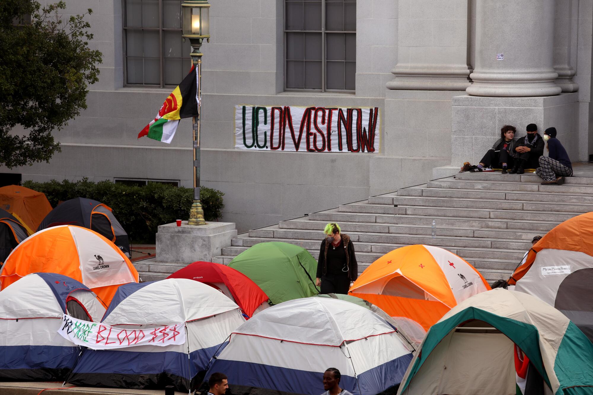 Students and concerned citizens camp in front of a campus building.