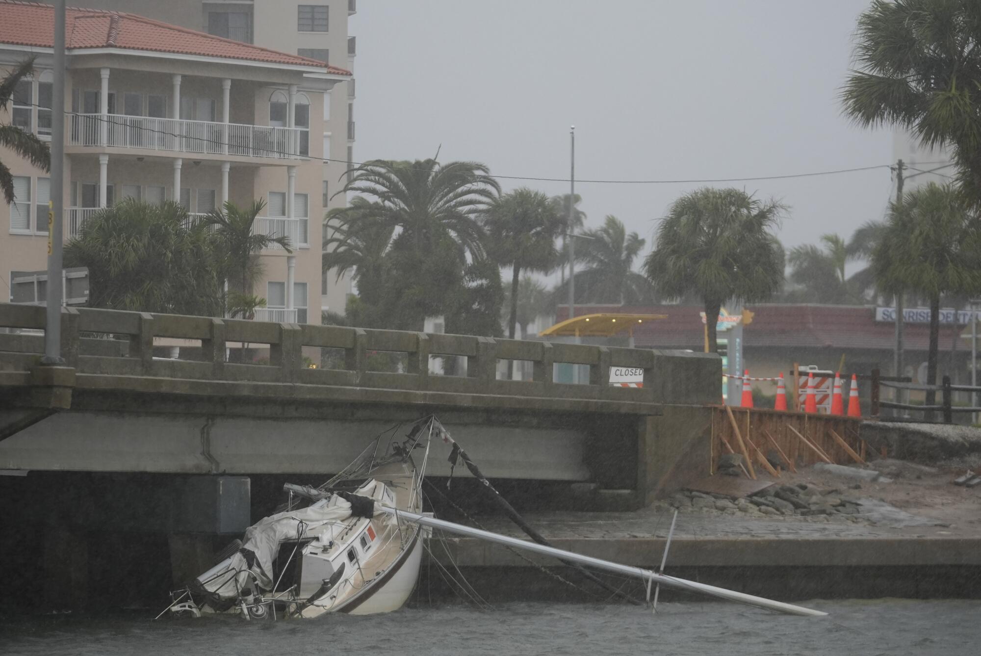 Un barco medio hundido cerca del puente.