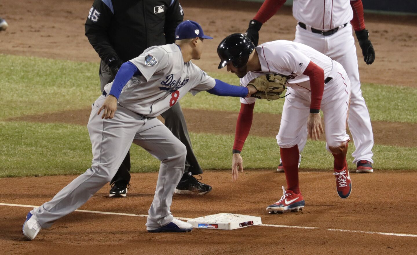 Dodgers' Manny Machado tags out Red Sox Ian Kinsler at third base in the second inning.
