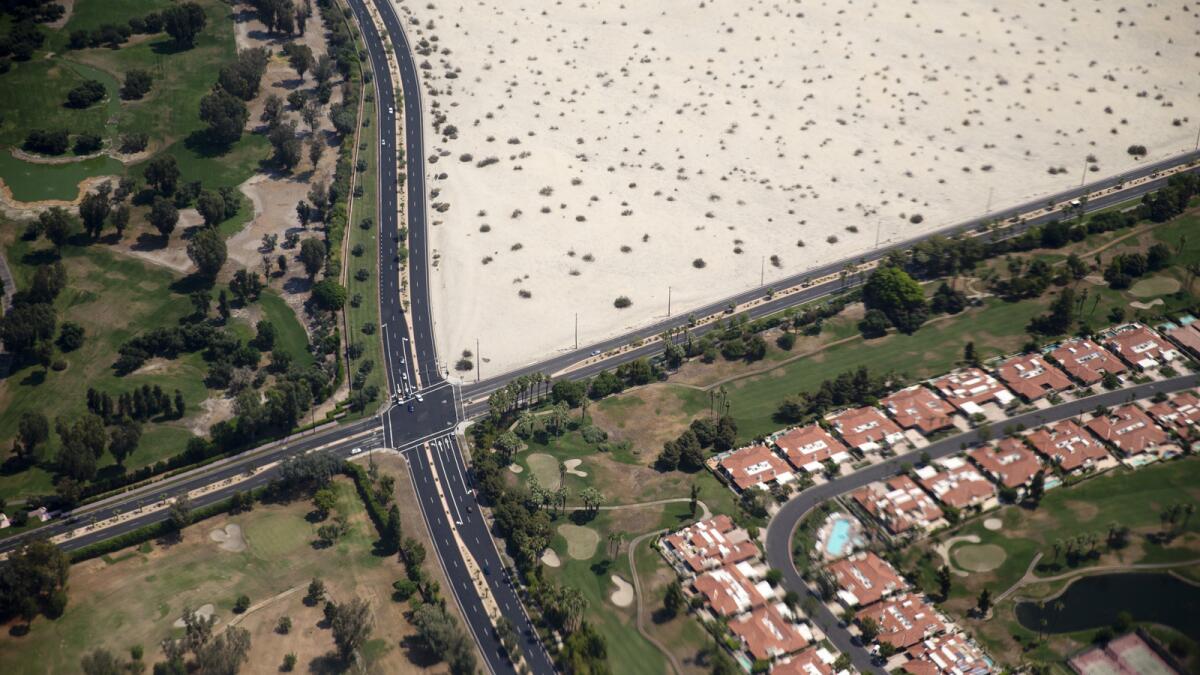 A green golf course community next to undeveloped land near Palm Springs International Airport.