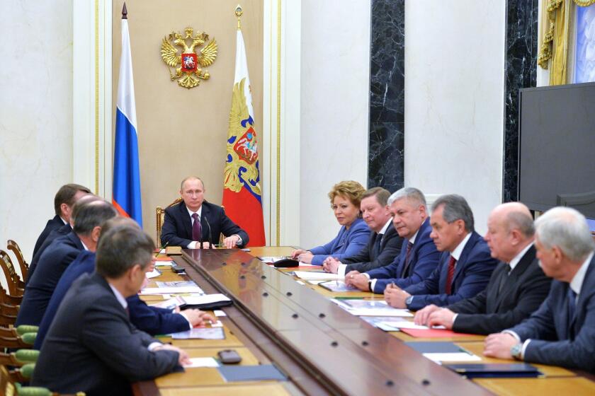 Russian President Vladimir Putin leads a Security Council meeting at the Kremlin in Moscow on Dec. 26, after which he signed into law a revised defense doctrine.