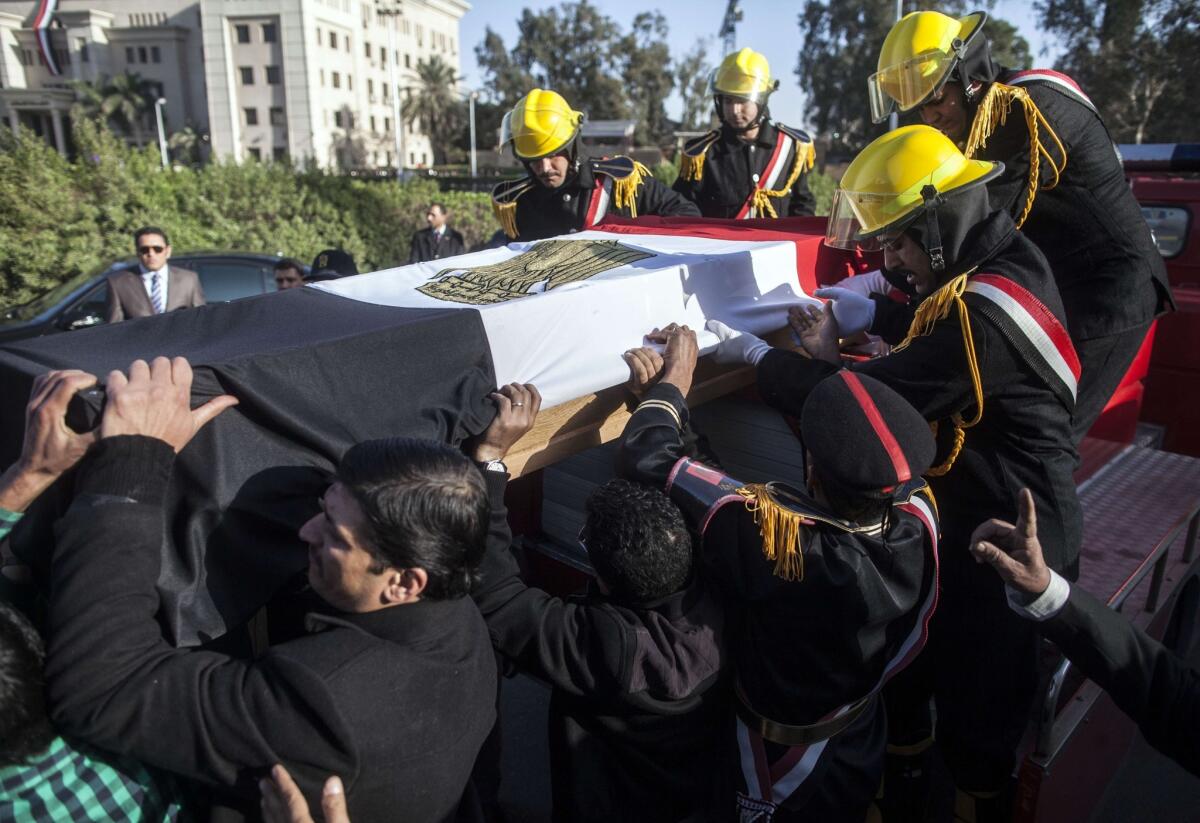 Mourners and members of the Egyptian security forces carry the coffin of police Gen. Mohamed Saeed, who was killed outside his home in Cairo.