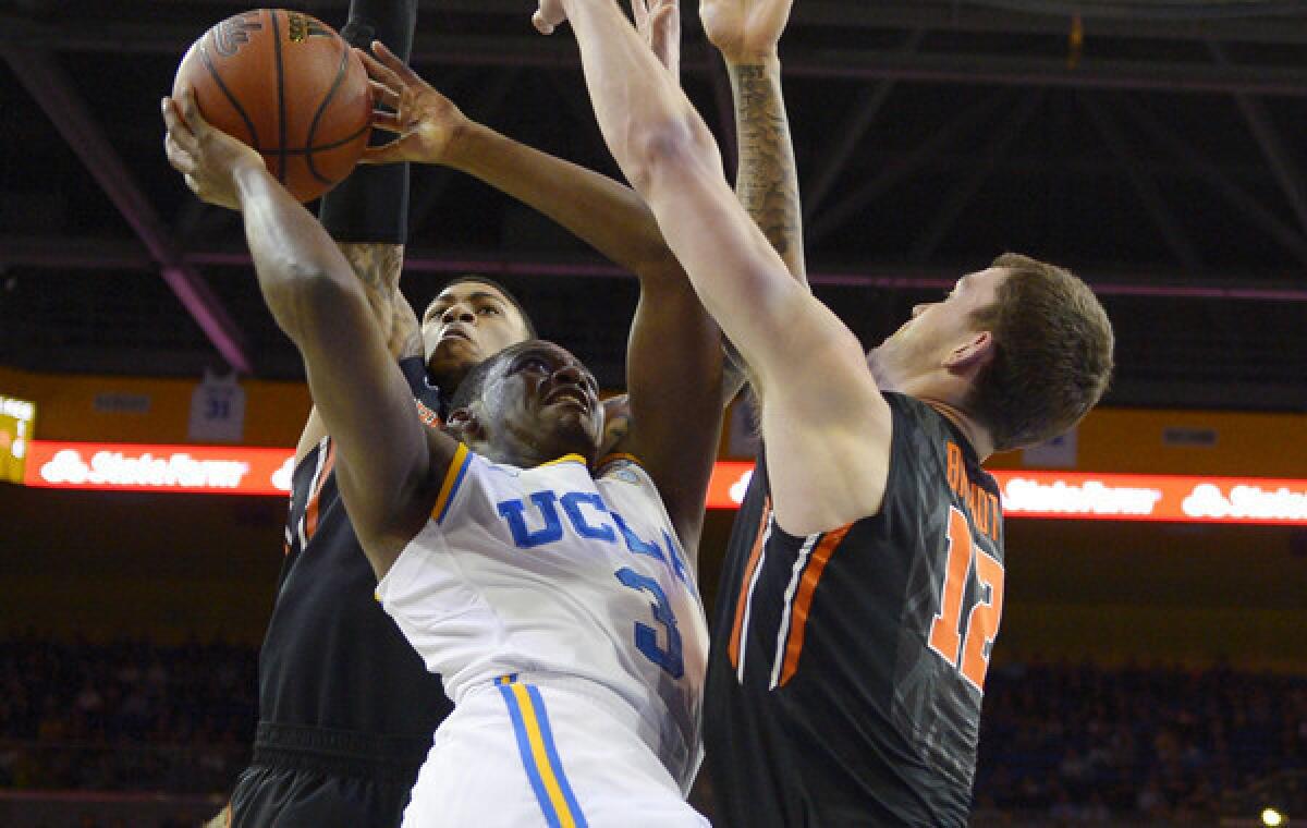 UCLA's Jordan Adams, puts up a shot between Oregon State's Eric Moreland, left, and Angus Brandt during the first half of the Bruins' 74-69 win Sunday.