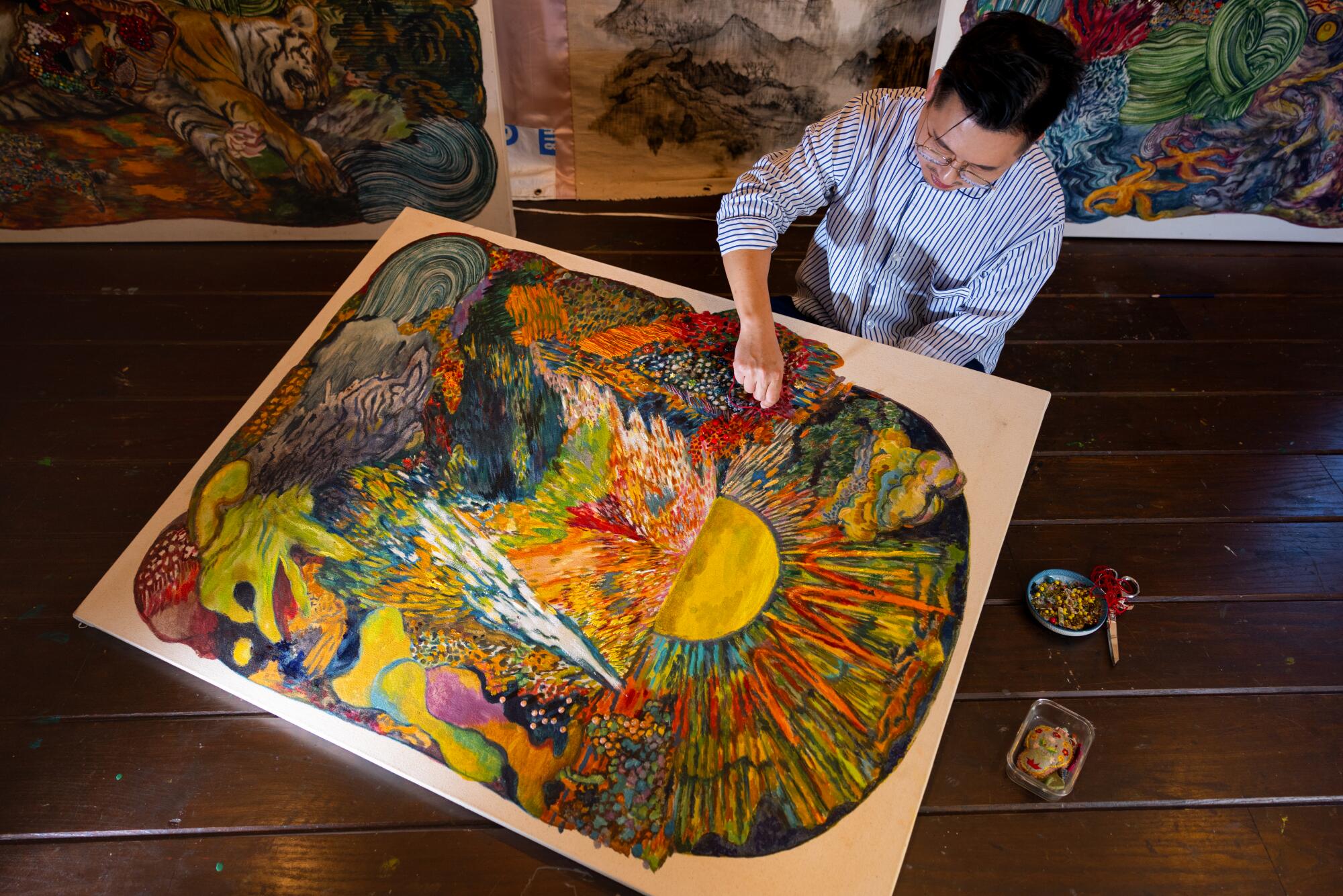 O artista Ken Gun Min borda sua pintura à mão