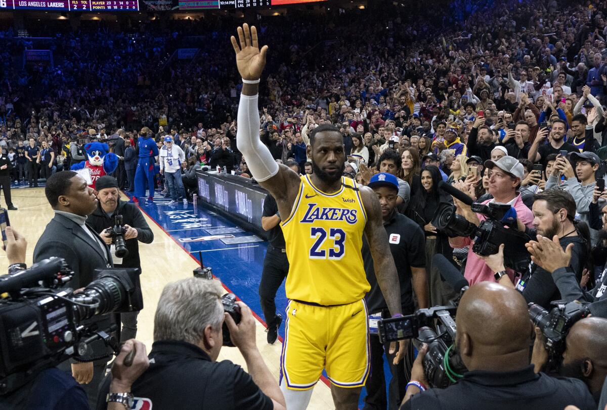 El alero de los Lakers, LeBron James, reconoce la ovación de los fanáticos después de pasar a Kobe Bryant por el No. 3 en la lista de anotadores de todos los tiempos de la NBA el sábado en Filadelfia.