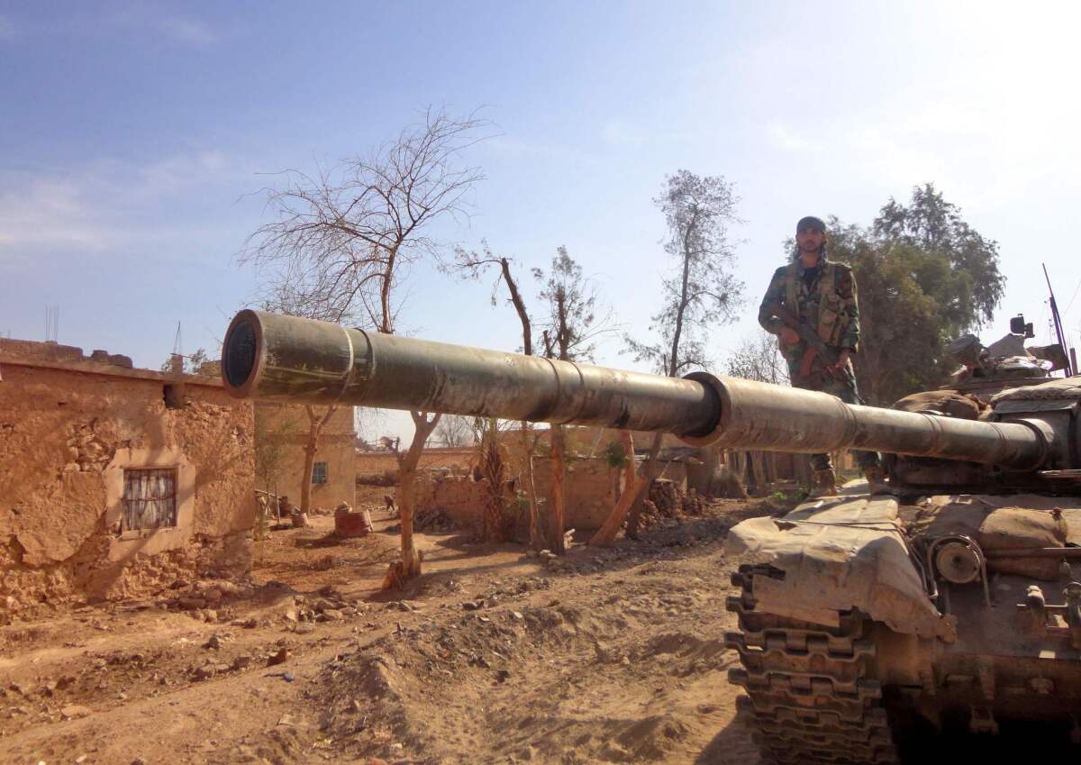 A Syrian army soldier stands atop a tank in a government-held area of the northeastern Syrian city of Dair Alzour on Nov. 12, 2016.