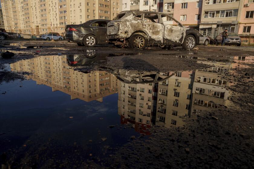 Destroyed cars are reflected in a pool of water after a Russian airstrike on residential neighbourhood in Sumy, Ukraine, on Saturday, Aug. 17, 2024. (AP Photo/Evgeniy Maloletka)