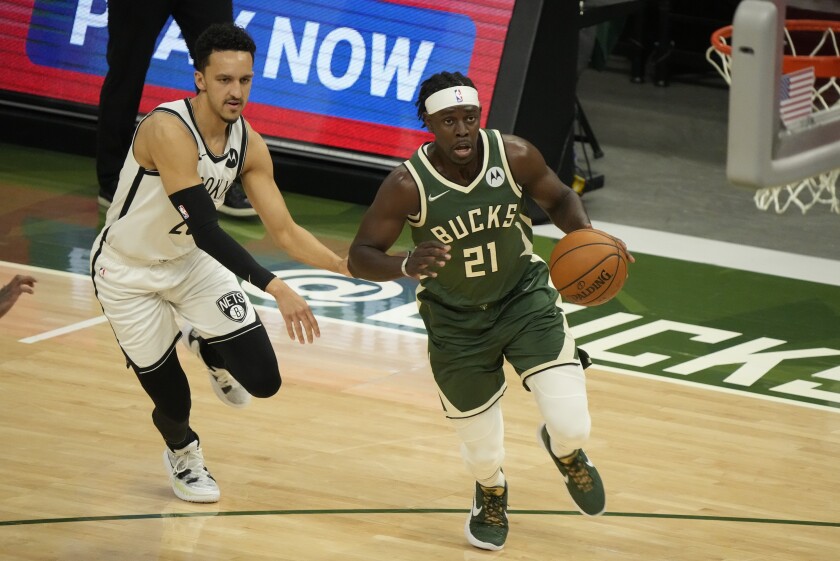 Milwaukee Bucks' Jrue Holiday drives past Brooklyn Nets' Landry Shamet during the first half of Game 3 of the NBA Eastern Conference basketball semifinals game Thursday, June 10, 2021, in Milwaukee. (AP Photo/Morry Gash)