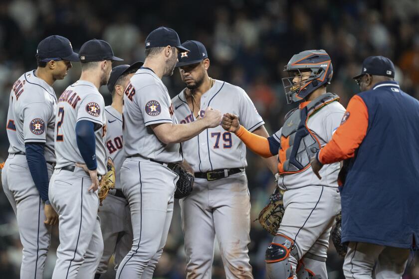 Houston Astros starting pitcher Justin Verlander gets a fist bump from catcher Marten Maldonado, second from right, before getting pulled by manager Dusty Baker, far right, in a meeting at the mound with shortstop Jeremy Pena, far left, third baseman Alex Bregman, second from left, and first baseman Jose Abreu (79) in the ninth inning of a baseball game against the Seattle Mariners, Monday, Sept. 25, 2023, in Seattle. The Astros won 5-1. (AP Photo/Stephen Brashear)
